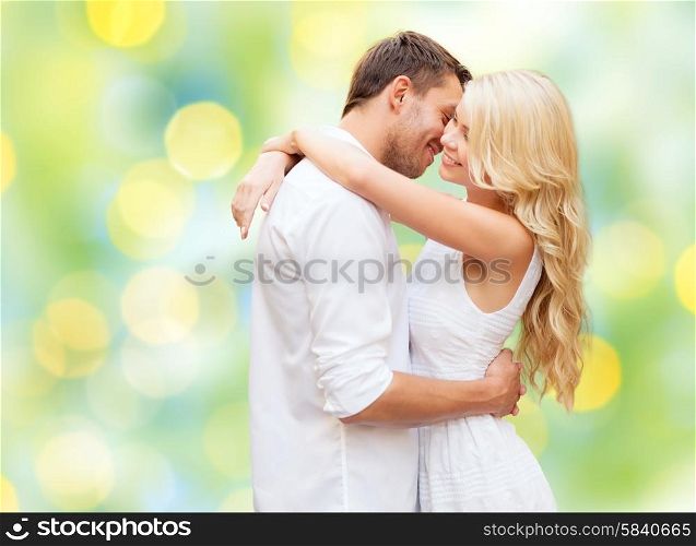 summer holidays, people, love and dating concept - happy couple hugging over green lights background
