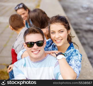 summer holidays, relationships and teenage concept - smiling teenagers having fun outside