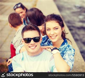 summer holidays, relationships and teenage concept - smiling teenagers having fun outside