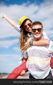 summer holidays, relationships and teenage concept - smiling teenagers in sunglasses having fun outside