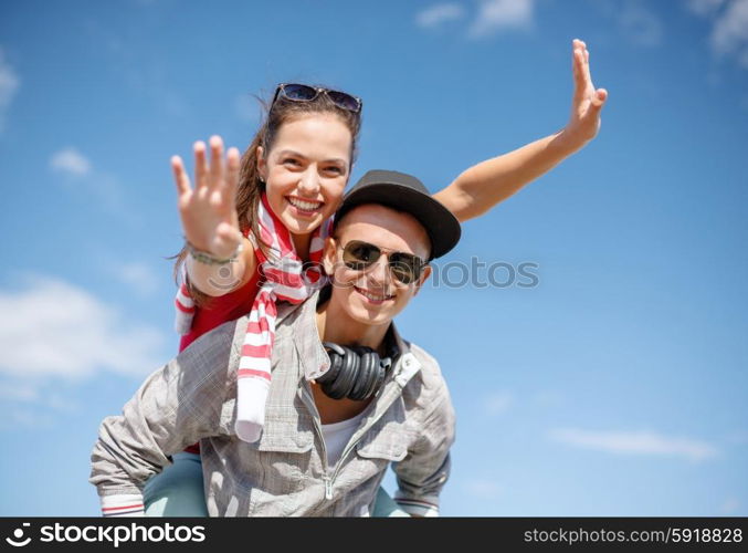 summer holidays, relationships and teenage concept - smiling teenagers in sunglasses having fun outside