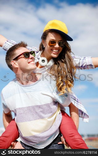 summer holidays, relationships and teenage concept - smiling teenagers in sunglasses having fun outside