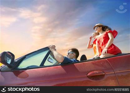 summer holidays, road trip and travel concept - happy friends driving in convertible car over sky background. happy friends driving in convertible car over sky. happy friends driving in convertible car over sky