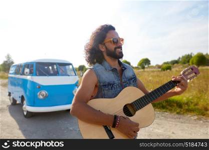 summer holidays, road trip, travel and people concept - happy smiling hippie man playing guitar near minivan car outdoors. hippie man playing guitar at minivan car outdoor