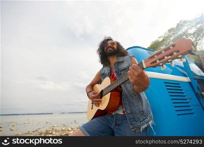 summer holidays, road trip, travel and people concept - happy smiling hippie man playing guitar near minivan car outdoors. hippie man playing guitar at minivan car outdoor