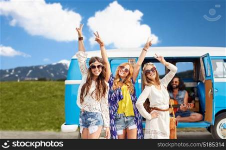 summer holidays, road trip, travel and people concept - happy young hippie friends showing peace hand sign and posing at minivan car over alps mountains background. happy hippie friends at minivan car outdoors
