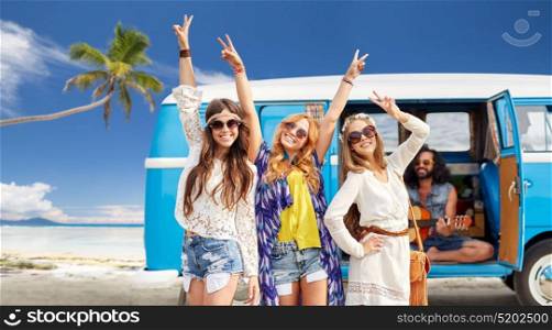 summer holidays, road trip, travel and people concept - happy young hippie friends showing peace hand sign and posing at minivan car over tropical beach background. happy hippie friends at minivan car on beach