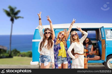 summer holidays, road trip, travel and people concept - happy young hippie friends showing peace hand sign and posing at minivan car over tropical beach background. happy hippie friends at minivan car on beach