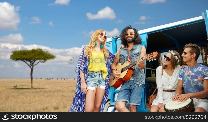 summer holidays, road trip, travel and people concept - happy young hippie friends with guitar and drum playing music at minivan car over african savannah background. hippie friends playing music at minivan in africa