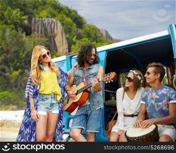 summer holidays, road trip, travel and people concept - happy young hippie friends with guitar and drum playing music at minivan car over island beach background. hippie friends playing music at minivan on beach