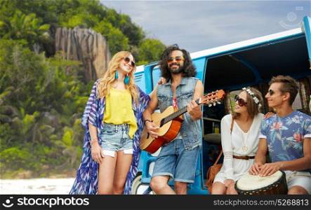 summer holidays, road trip, travel and people concept - happy young hippie friends with guitar and drum playing music at minivan car over island beach background. hippie friends playing music at minivan on island