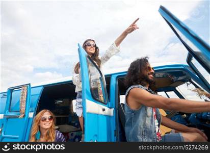 summer holidays, road trip, travel and people concept - smiling happy young hippie friends in minivan car at seaside. smiling happy young hippie friends at minivan car