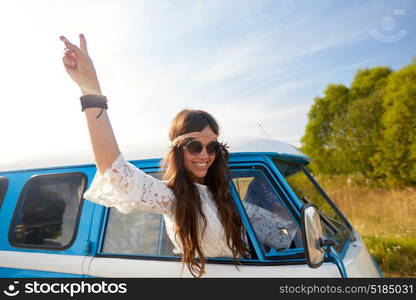 summer holidays, road trip, travel and people concept - smiling young hippie woman showing peace gesture in minivan car. happy hippie woman showing peace in minivan car