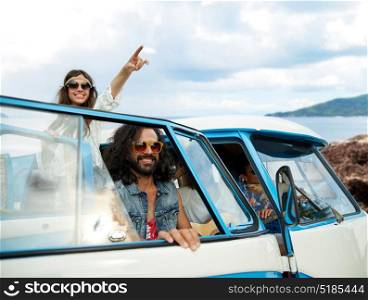 summer holidays, road trip, travel and people concept - smiling young hippie friends in minivan car over island and sea background. happy hippie friends in minivan car on island