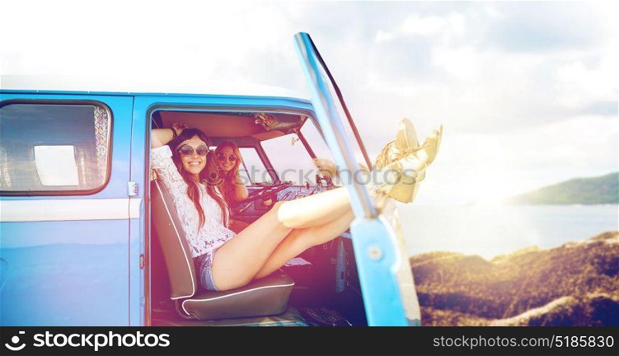 summer holidays, road trip, travel and people concept - smiling young hippie women resting in minivan car over beach background. happy hippie women in minivan car on summer beach