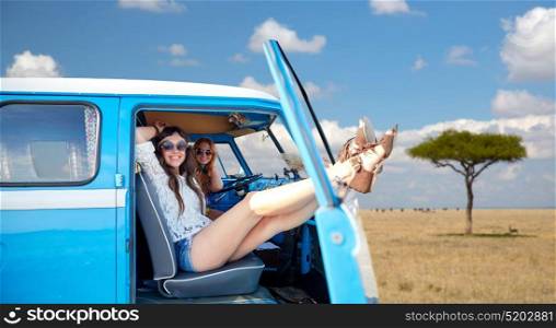 summer holidays, road trip, travel and people concept - smiling young hippie women resting in minivan car over african savannah background. happy hippie women in minivan car in africa