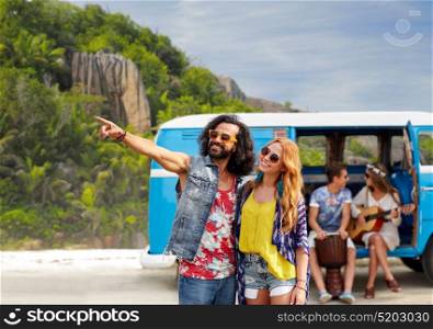 summer holidays, road trip, travel and people concept - smiling young hippie couple with friends in minivan car over exotic island beach background. happy hippie couples and minivan on island