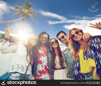 summer holidays, road trip, travel and people concept - smiling young hippie friends at minivan car showing peace hand sign over beach background. hippie friends at minivan car showing peace sign