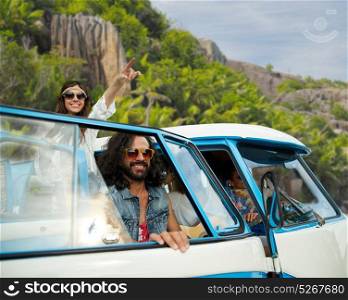 summer holidays, road trip, travel and people concept - smiling young hippie friends in minivan car over tropical island background. happy hippie friends in minivan car on island