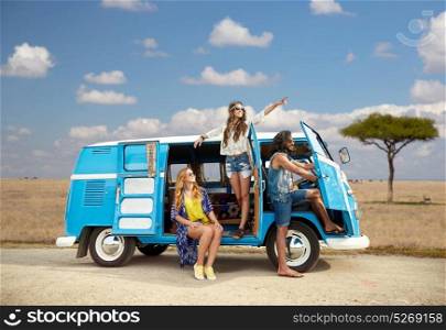 summer holidays, road trip, travel and people concept - smiling young hippie friends in minivan car over african savannah background. happy hippie friends in minivan car in africa