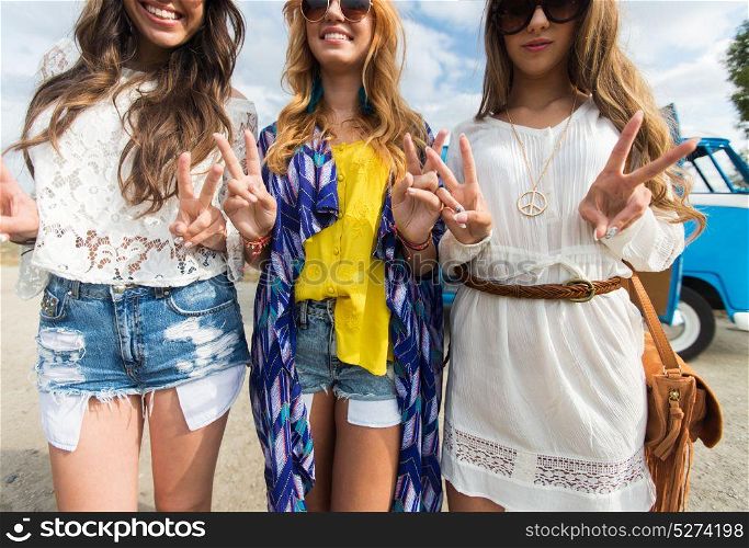 summer holidays, road trip, travel and people concept - smiling young hippie women showing peace sign over minivan car. smiling young hippie women showing peace sign
