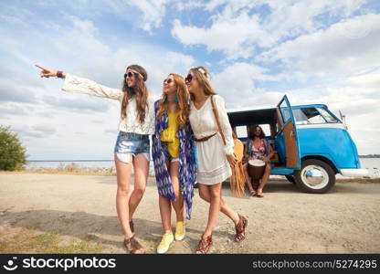 summer holidays, road trip, travel and people concept - smiling young hippie friends in minivan car on beach at seaside. smiling young hippie friends near minivan car