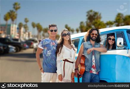 summer holidays, road trip, vacation and travel concept - smiling young hippie friends with guitar over minivan car. hippie friends over minivan car at venice beach