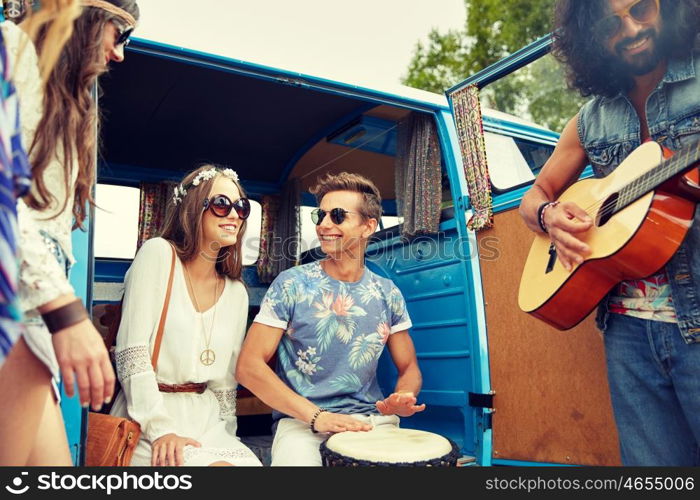 summer holidays, road trip, vacation, travel and people concept - happy young hippie friends having fun and playing music over minivan car