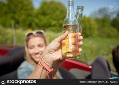 summer holidays, road trip, vacation, travel and people concept - happy young women with fizzy drinks driving in convertible car
