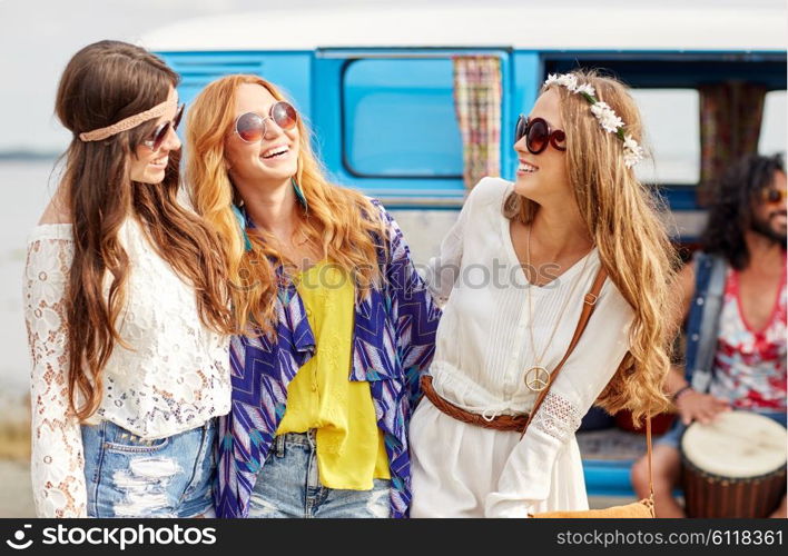 summer holidays, road trip, vacation, travel and people concept - happy young hippie friends having fun and talking over minivan car