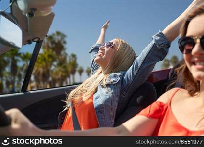 summer holidays, road trip, vacation, travel and people concept - happy young women driving in convertible car and laughing over venice beach background in california. happy young women driving in car over venice beach. happy young women driving in car over venice beach