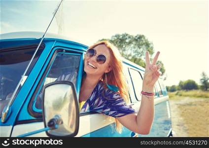 summer holidays, road trip, vacation, travel and people concept - smiling young hippie woman driving minivan car and showing peace gesture