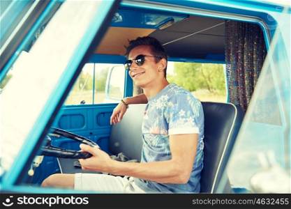 summer holidays, road trip, vacation, travel and people concept - smiling young hippie man driving in minivan car