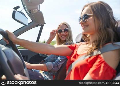 summer holidays, road trip, vacation, travel and people concept - smiling young women driving in in cabriolet car