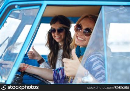 summer holidays, road trip, vacation, travel and people concept - smiling young hippie women driving and showing thumbs up gesture in minivan car