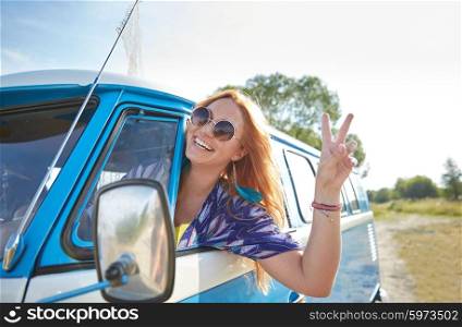 summer holidays, road trip, vacation, travel and people concept - smiling young hippie woman driving minivan car and showing peace gesture