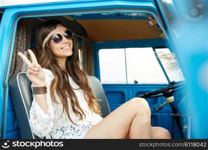 summer holidays, road trip, vacation, travel and people concept - smiling young hippie woman showing peace gesture in minivan car