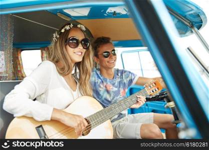summer holidays, road trip, vacation, travel and people concept - smiling young hippie couple with guitar playing music in minivan car