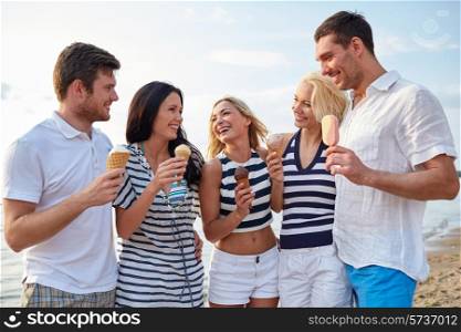 summer, holidays, sea, tourism and people concept - group of smiling friends eating ice cream and talking on beach