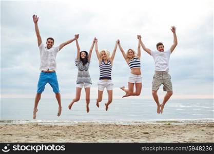 summer, holidays, sea, tourism and people concept - group of smiling friends in sunglasses walking on beach