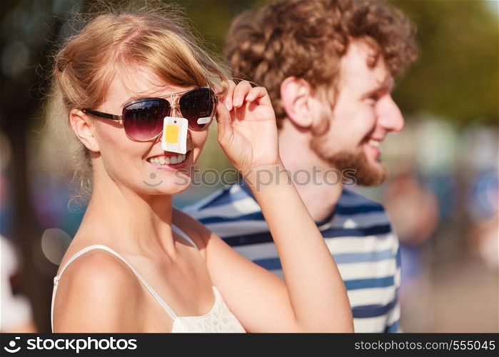 Summer holidays shopping concept. Young couple of tourists buying new sunglasses in street stall outdoor