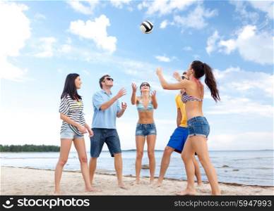summer holidays, sport, leisure and people concept - group of happy friends playing beach ball