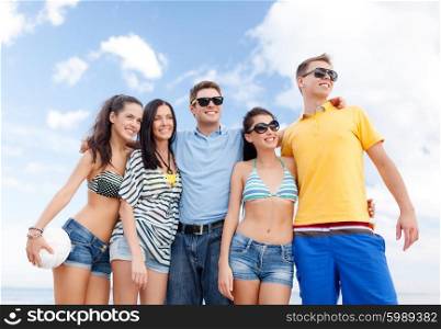 summer holidays, sport, leisure and people concept - group of happy friends with beach ball