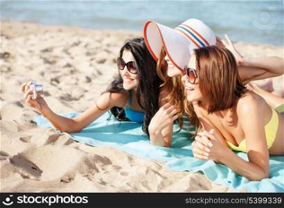 summer holidays, technology and beach concept - girls making self portrait on the beach