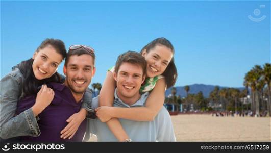 summer holidays, tourism and travel concept - group of happy friends or couples over venice beach background in california. group of happy friends. group of happy friends