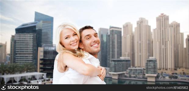 summer holidays, tourism, vacation, travel and dating concept - happy couple having fun over dubai city background