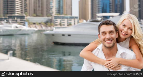 summer holidays, tourism, vacation, travel and dating concept - happy couple having fun over dubai city harbour or waterfront background