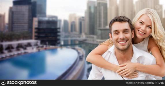 summer holidays, tourism, vacation, travel and dating concept - happy couple having fun over dubai city waterfront background