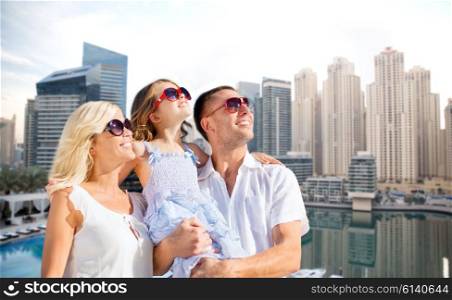 summer holidays, tourism, vacation, travel and people concept - happy family over dubai city waterfront background