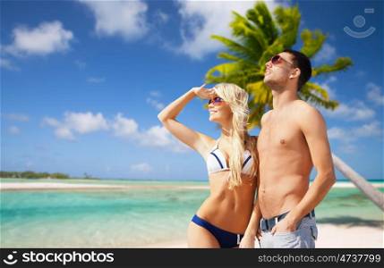 summer holidays, travel and vacation concept - happy couple over exotic tropical beach with palm trees background. happy couple over exotic tropical beach background. happy couple over exotic tropical beach background